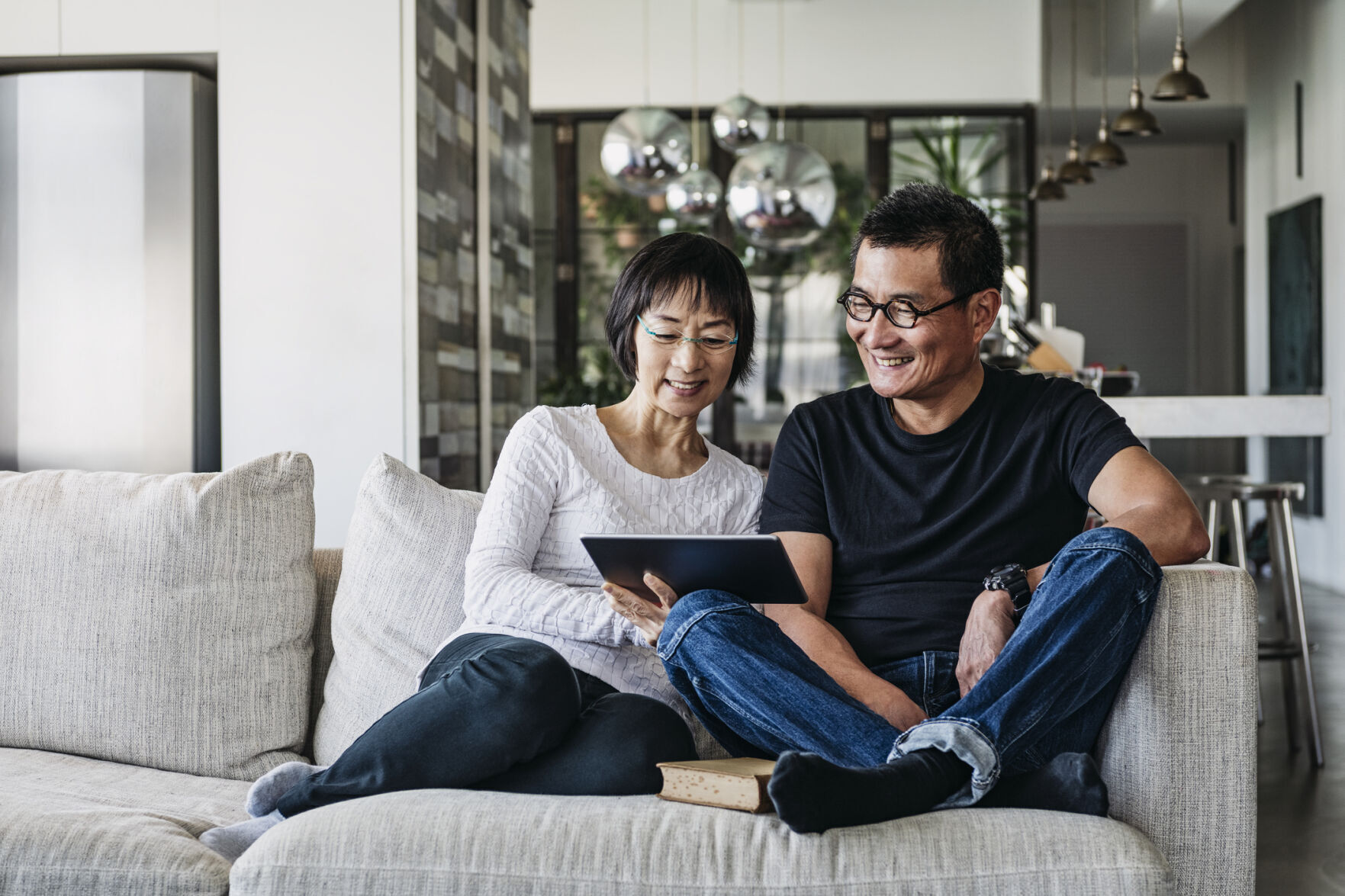 Chinese couple on sofa watching movie online